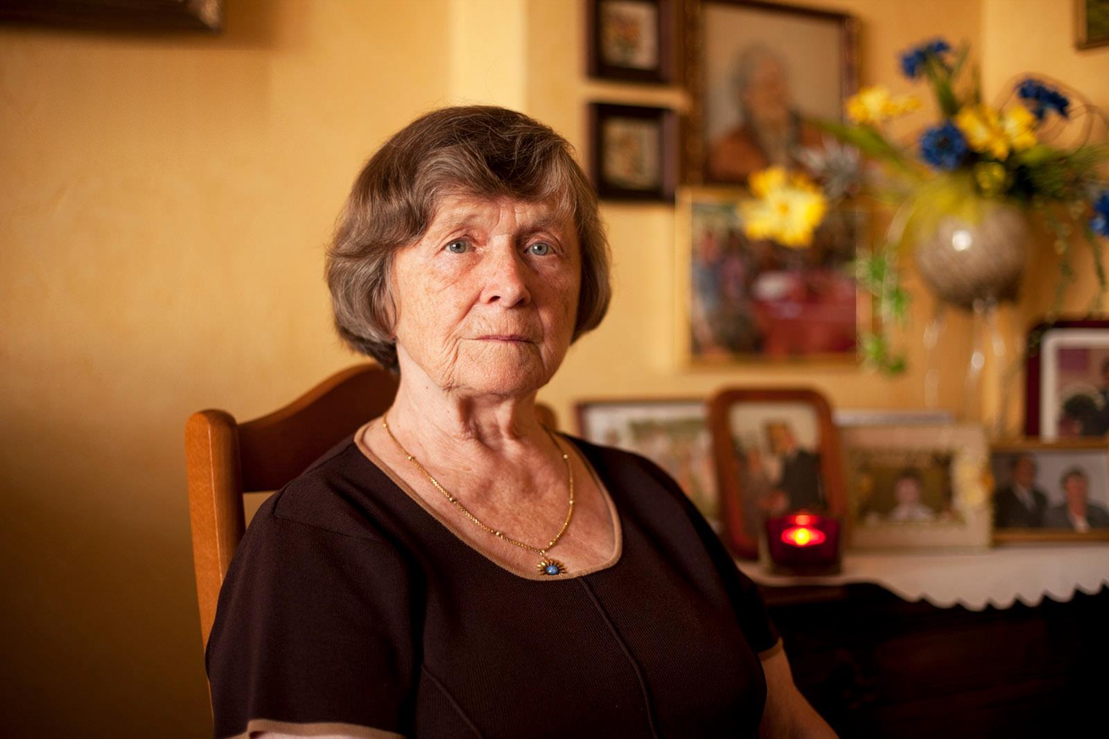 Portrait of an older woman seated at home in warm golden light